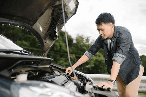 Person performing car repairs outdoors without a garage – practical solutions for vehicle maintenance.